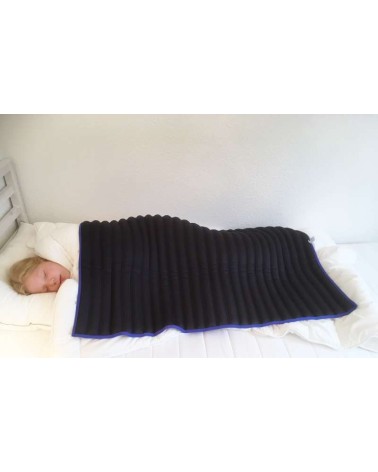 Beschwerungsdecke-blau. Mädchen liegt in ihrem Bett, unter der Decke.